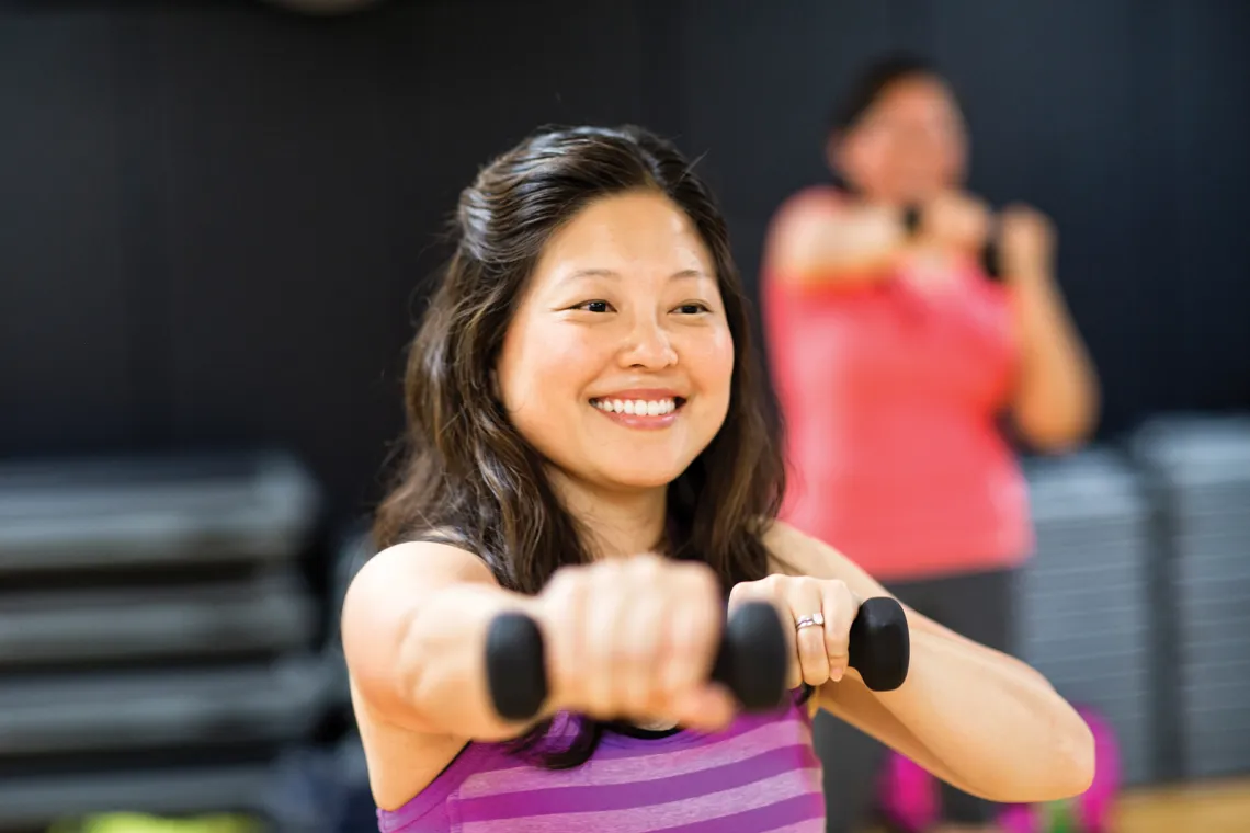 woman holding 2 dumbbells