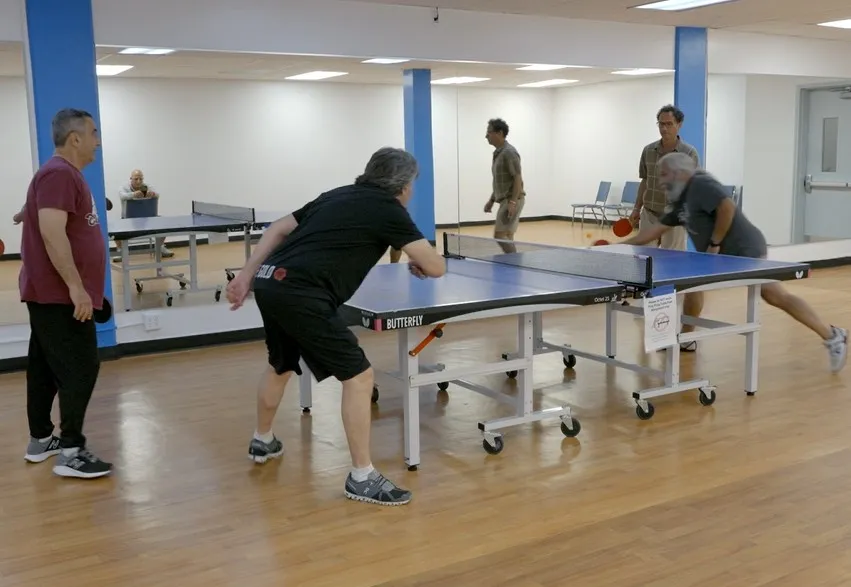4 players playing table tennis at the Y
